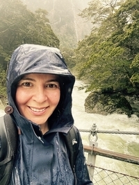 Luana smiling in the spring rain on the Routeburn